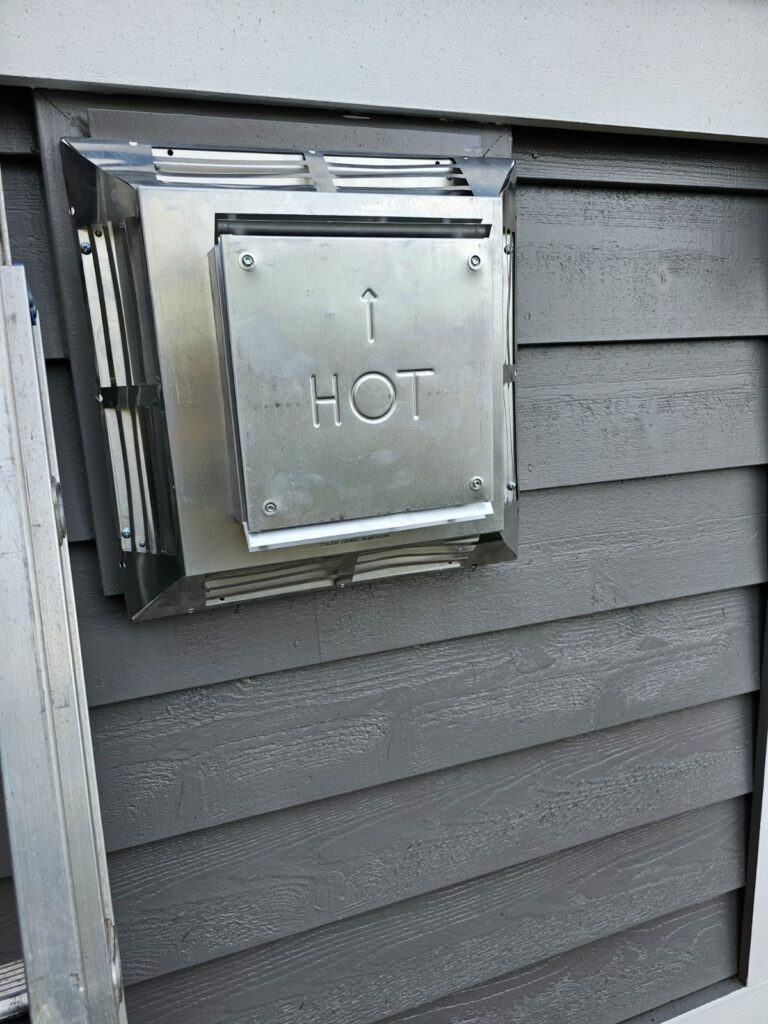 High-Efficiency Furnace Hot Exhaust Vent on Home Exterior