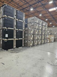 Multiple rows of large, grey storage units in a warehouse, each meticulously labeled and staged for distribution, highlighting readiness and order.